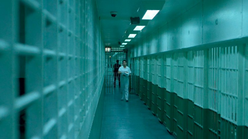Frank walking through cellblock at Ryker's Island correctional facility.