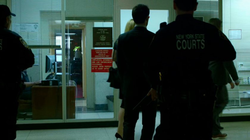 Matt, Karen, and Foggy led by police down a hallway in the courthouse.