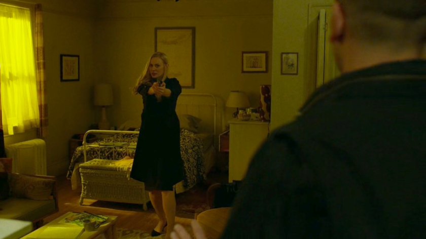 Karen holds a gun on Frank Castle in her apartment.