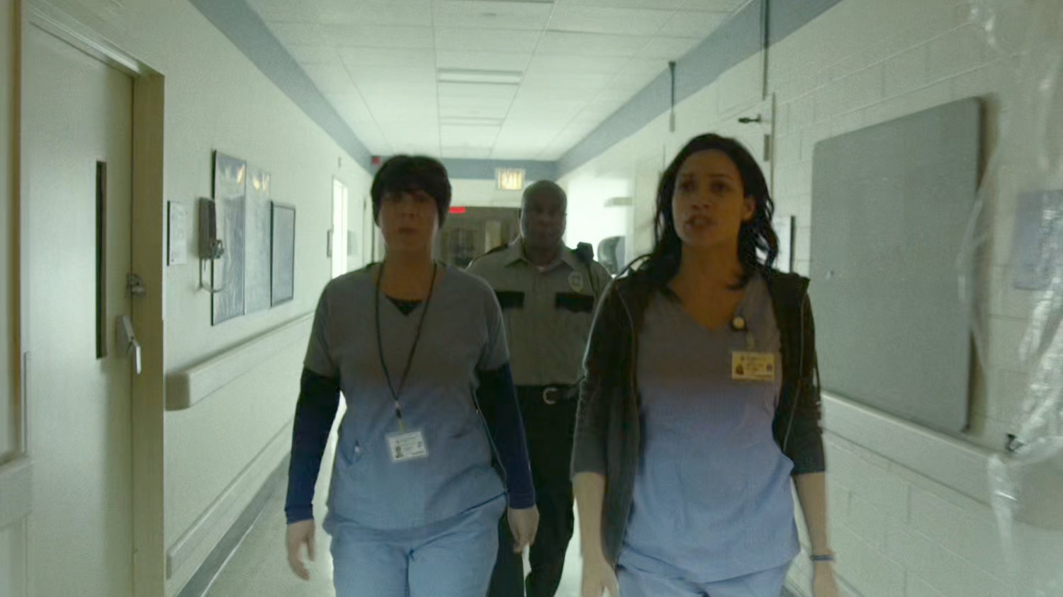 Louisa, Claire and security guard in hallway of the remodeled wing of Metro-General.