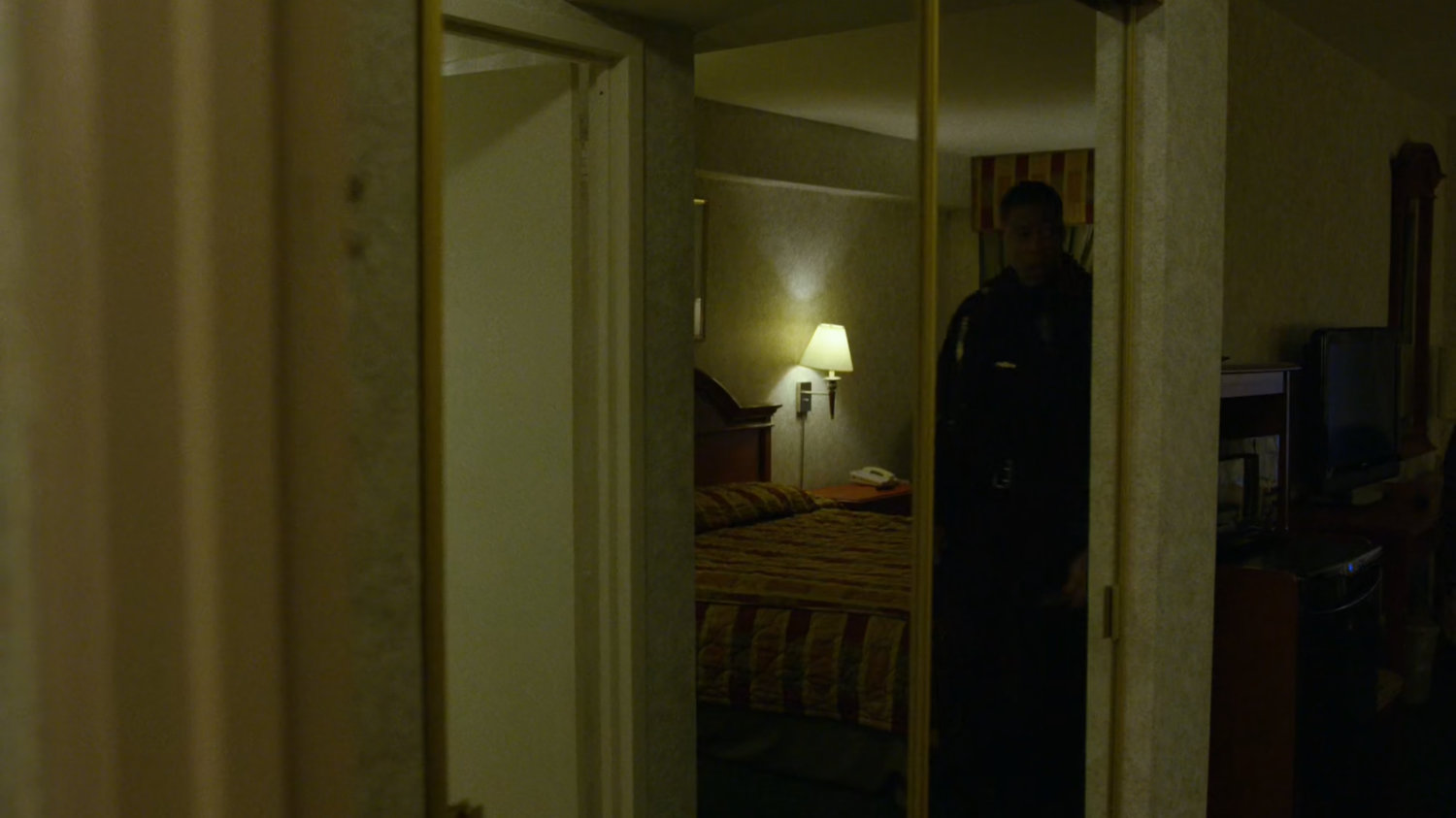 A police officer inspects Karen's room at the Hotel Travel Inn.