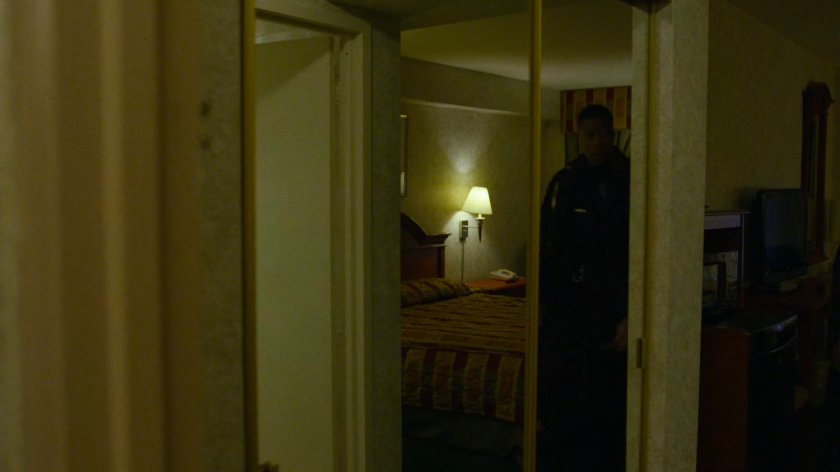 A police officer inspects Karen's room at the Hotel Travel Inn.