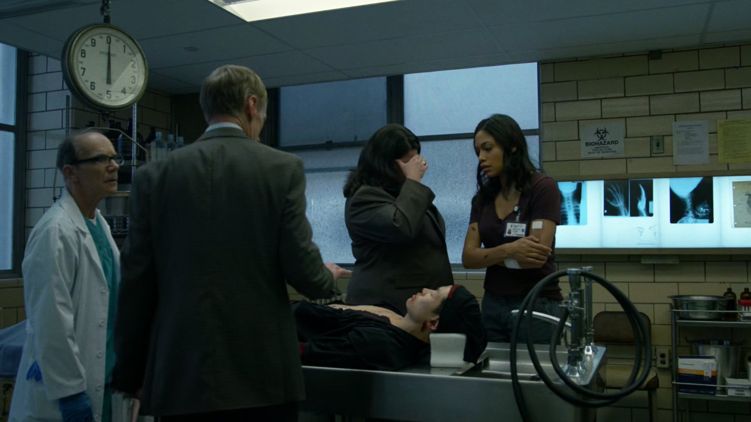 A Hospital administrator, doctor, Shirley and Claire standing over dead body in the Metro-General morgue.