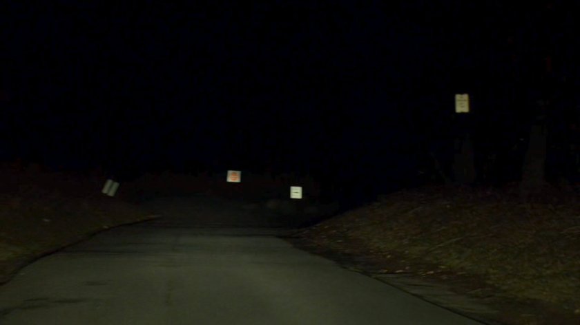 A dark, wooded road.