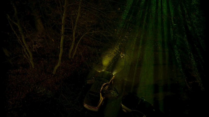 Aerial view of accident site on a dark, wooded road.