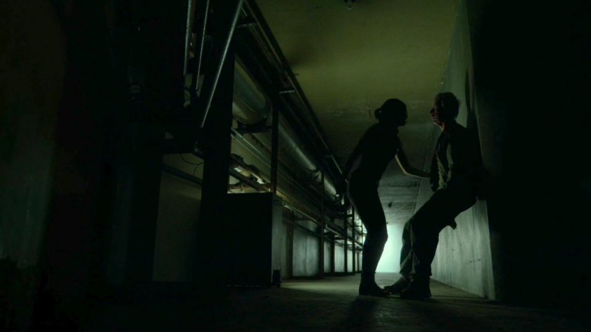 Elektra helping Stick through corridor of an abandoned steam plant.