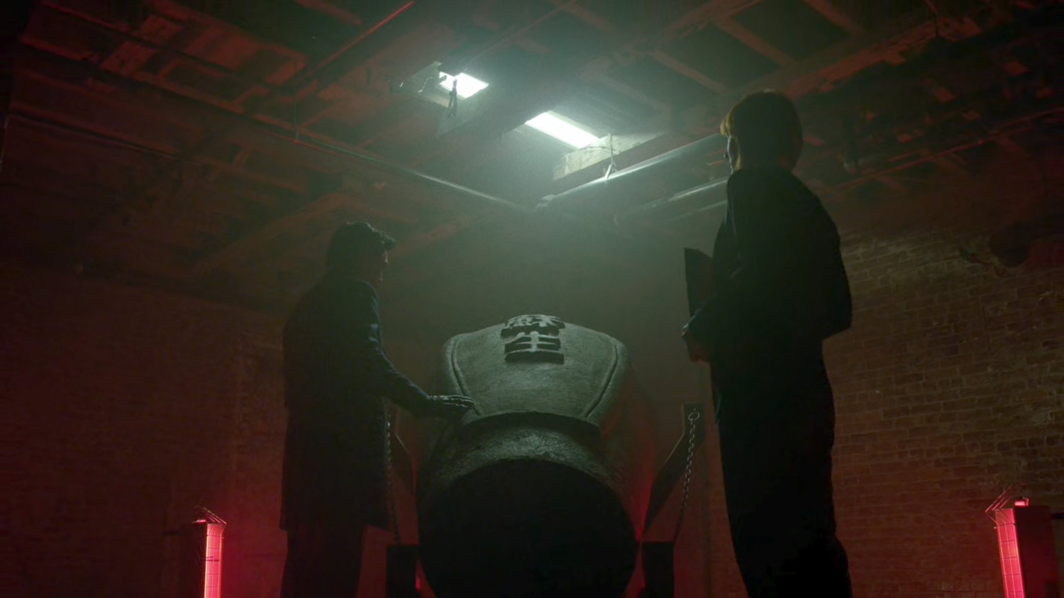 Nobu and Tyler stand by the Hand's Resurrection Sarcophagus in the basement of The Farm.