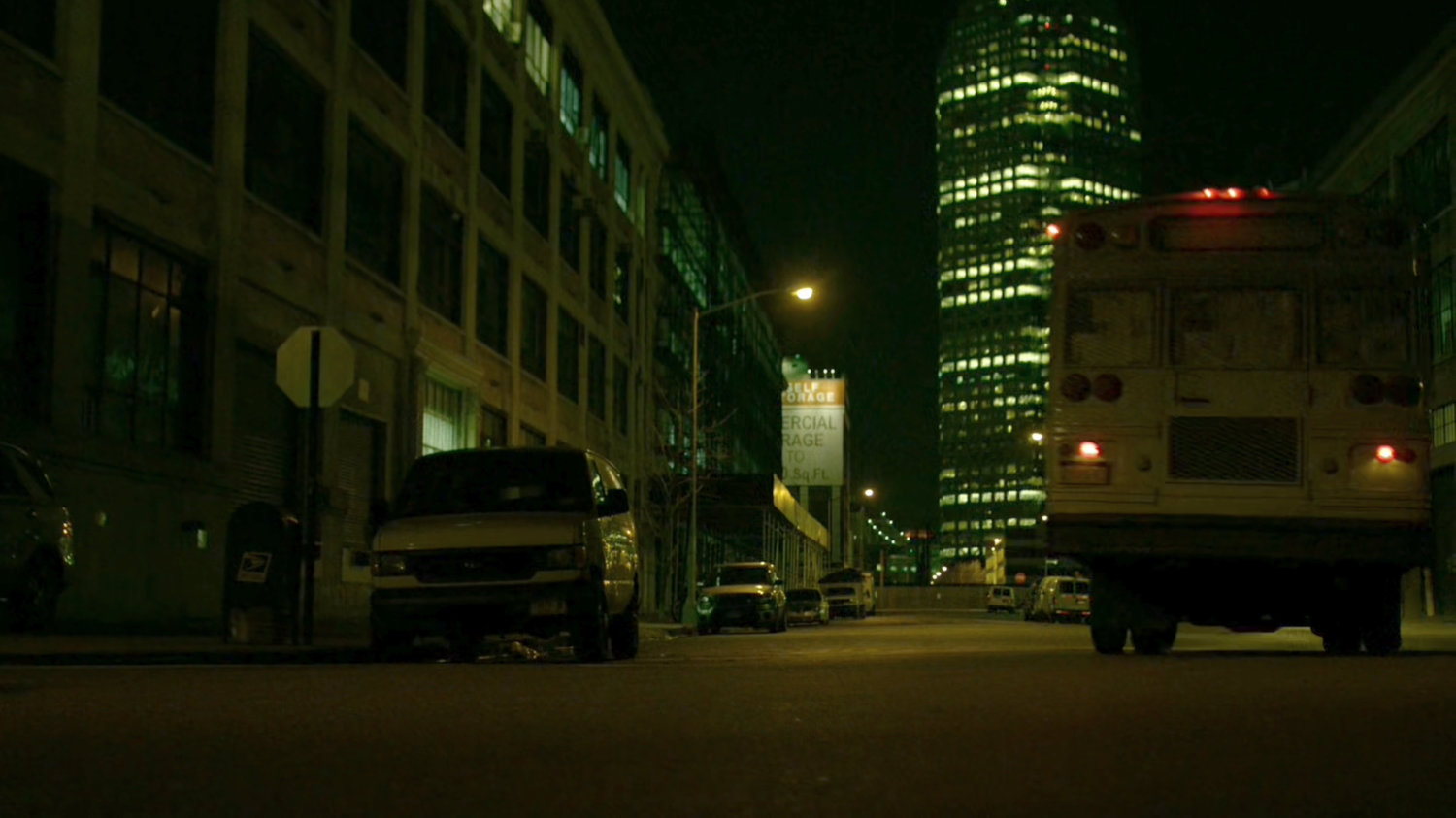 A bus belonging to The Hand drive along a dark street.