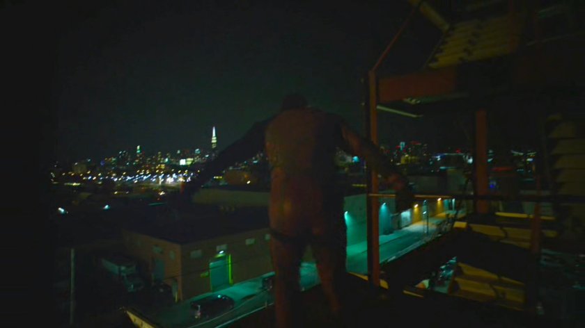 Daredevil swings from the girders of a construction site.