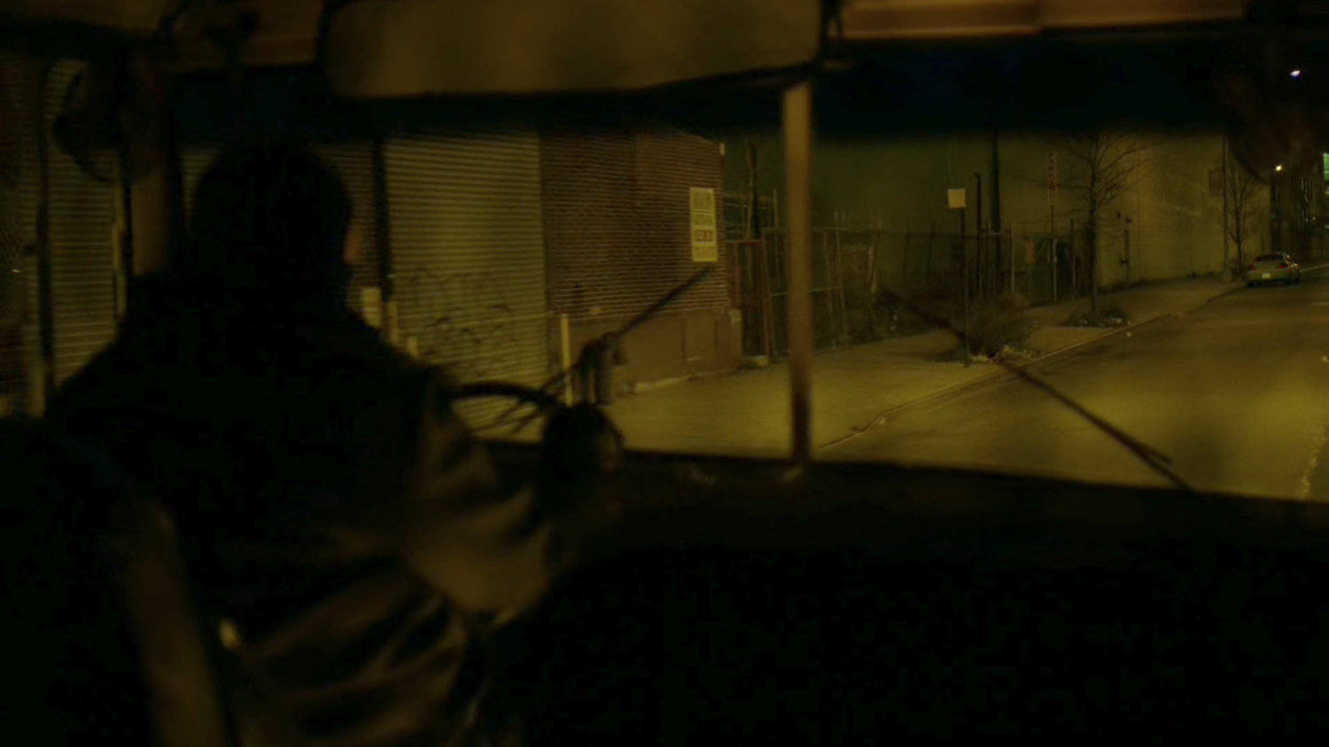A bus belonging to The Hand drive along a dark street.