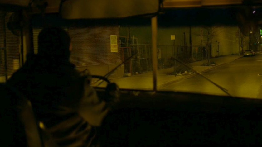 A bus belonging to The Hand drive along a dark street.