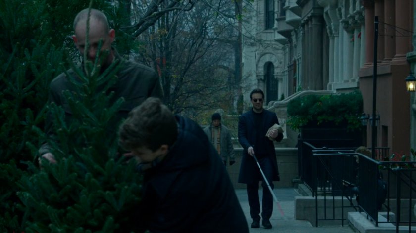 Matt walking along a sidewalk past people buying Christmas Tree.