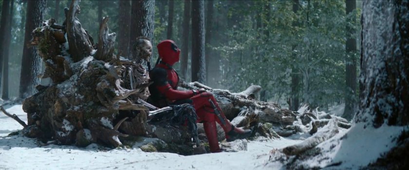 Deadpool and skeleton on fallen tree in snowy North Dakota woods.