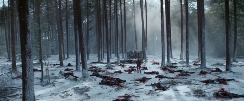 Deadpool standing in a snowy forest with dead TVA agents.