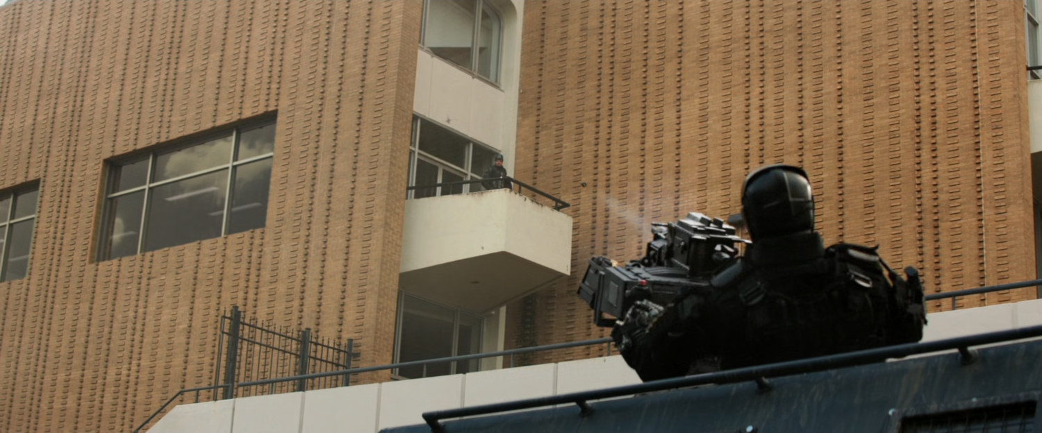 Crossbones firing grenade at Steve on a balcony at the IFID in Lagos.