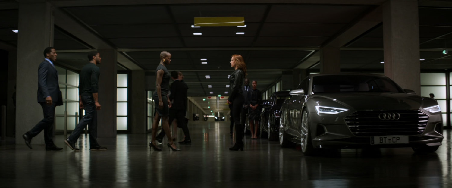 T'challa and his entourage walking towards Natasha in an underground parking lot.