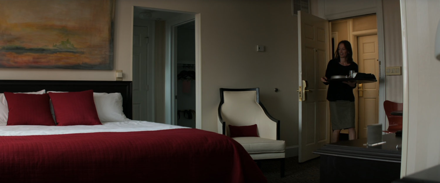 Room service entering an empty Berlin hotel room.