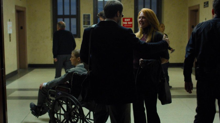Matt speaks with Aaron's mother in a court house hallway.