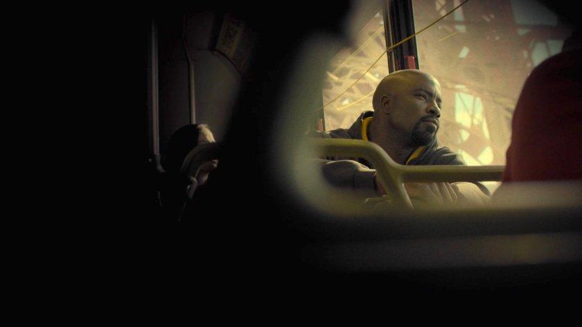 Luke Cage on a city bus crossing a bridge.