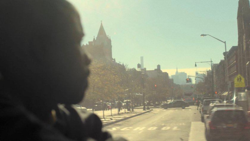 Luke Cage on city bus looking at a street in Harlem.