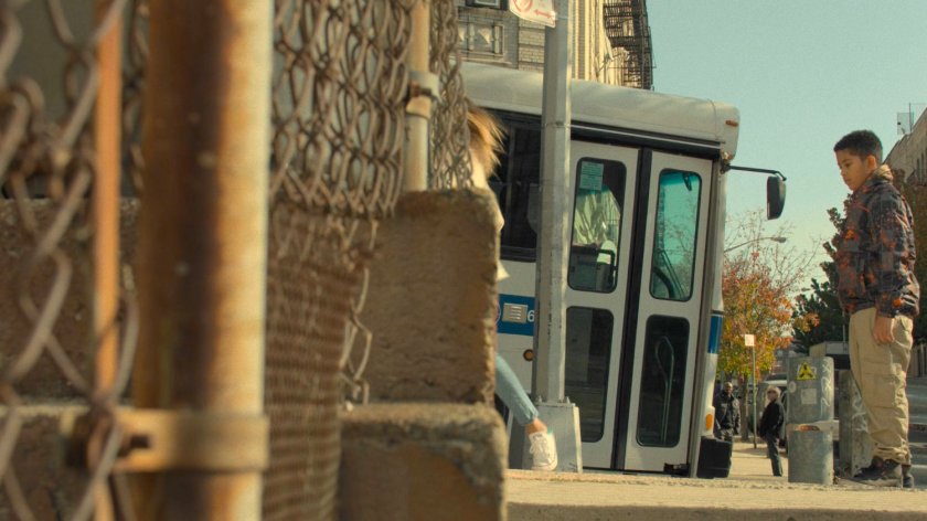A city bus pulling up to a Harlem corner.
