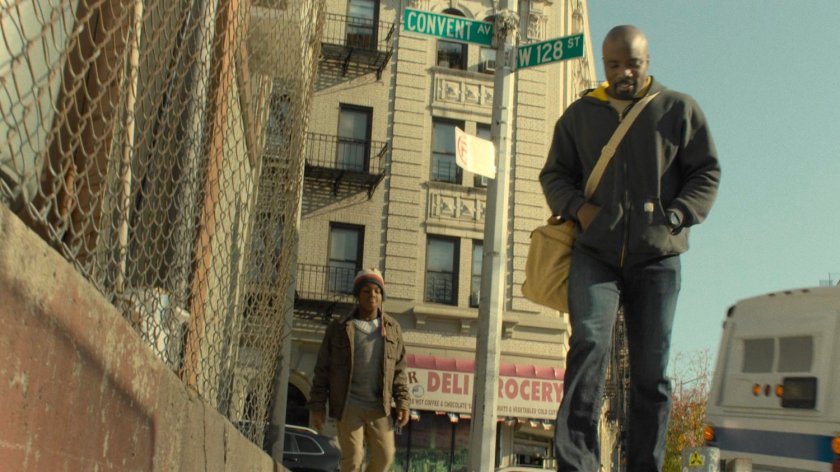 Luke Cage walking away from Harlem bus stop.