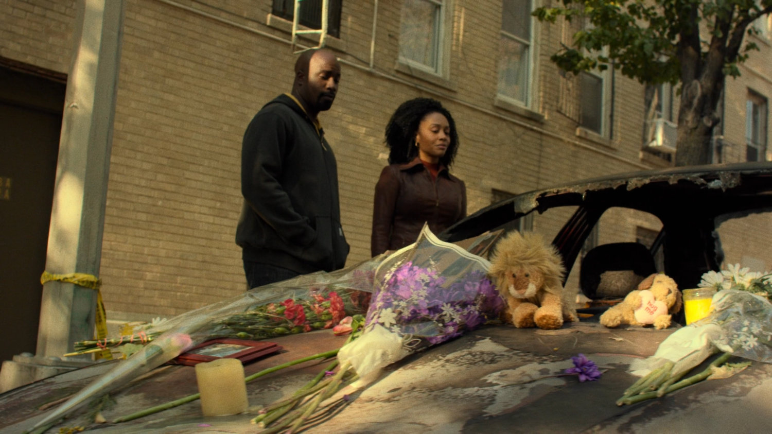 Luke and Misty stand by memorial along Harlem street.