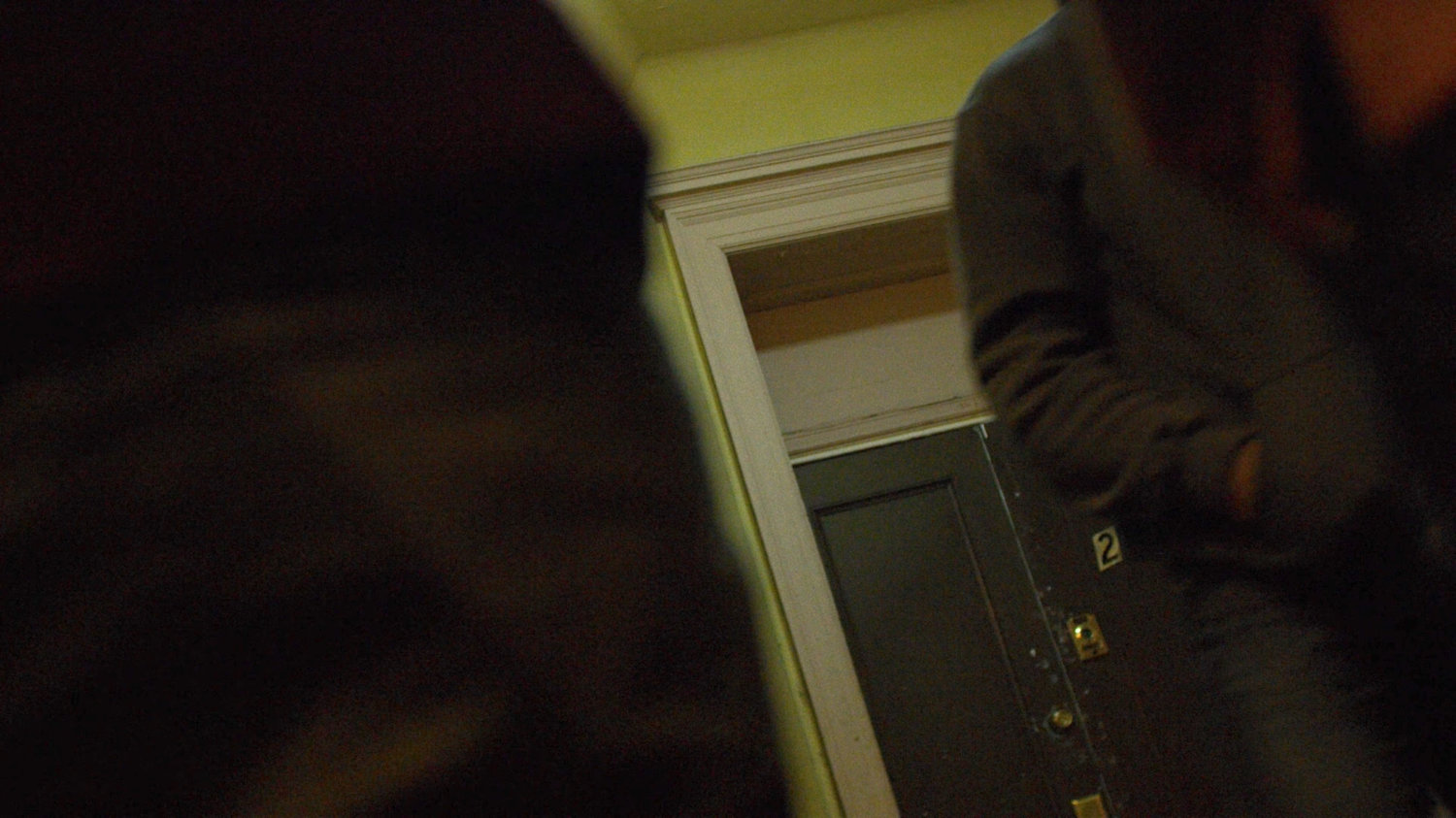 Luke walks past apartment in Cole Miller's building.