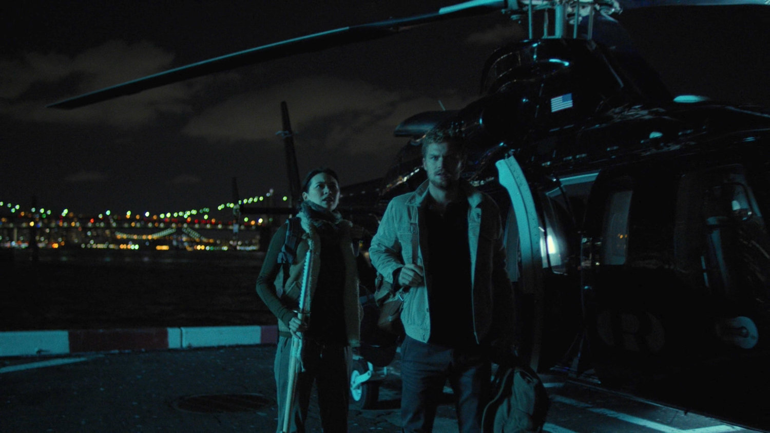 Colleen and Danny outside a helicopter at a city heliport.