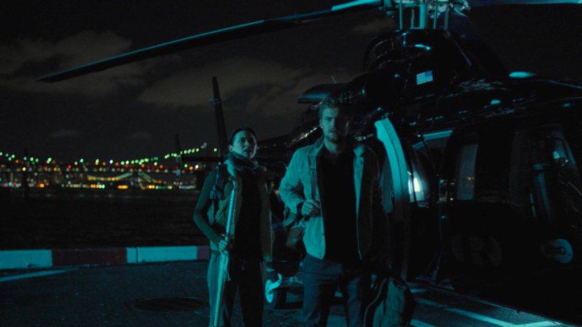 Colleen and Danny outside a helicopter at a city heliport.