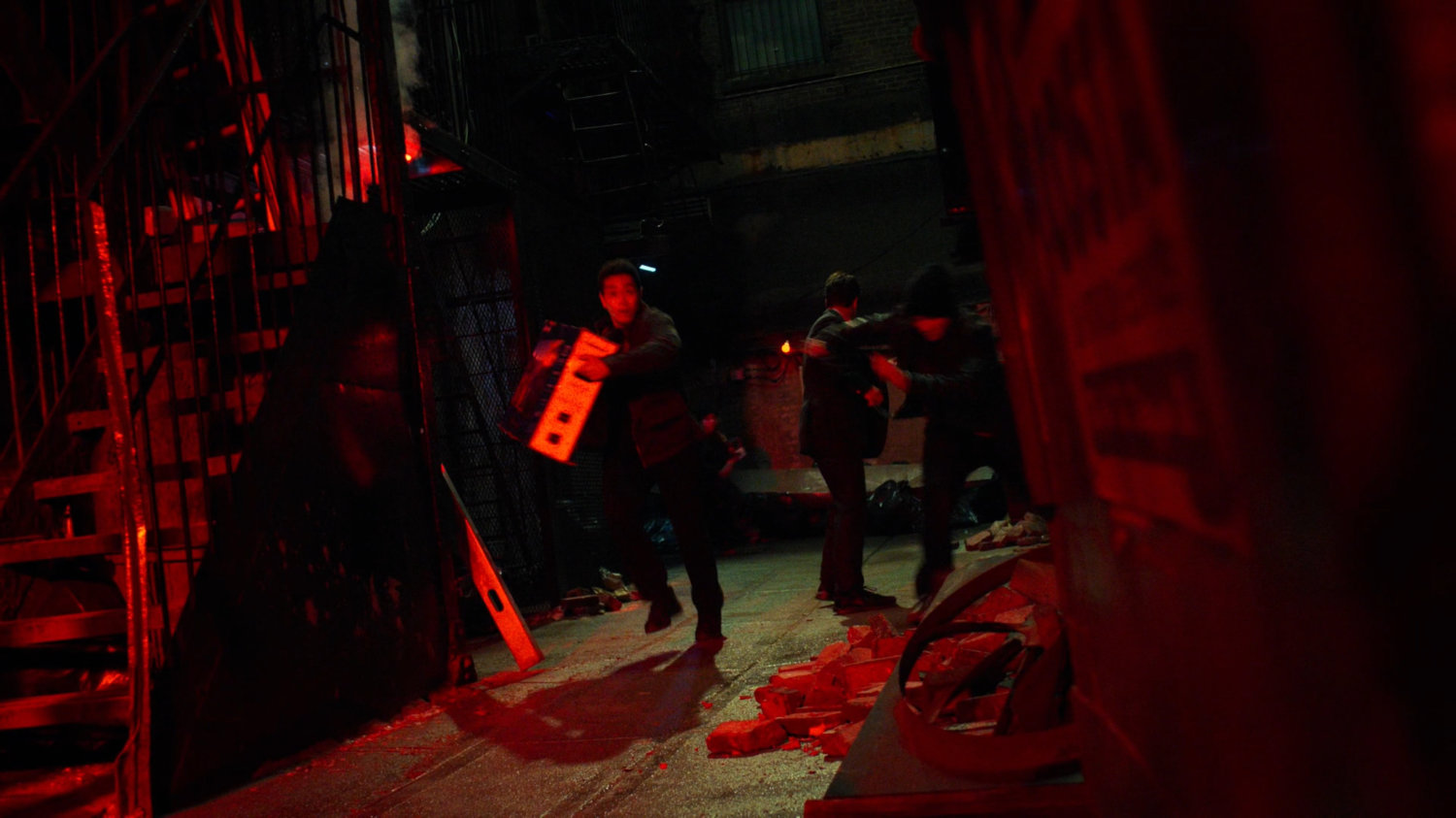 Youth running with a TV in an alley outside a pawn shop exit.