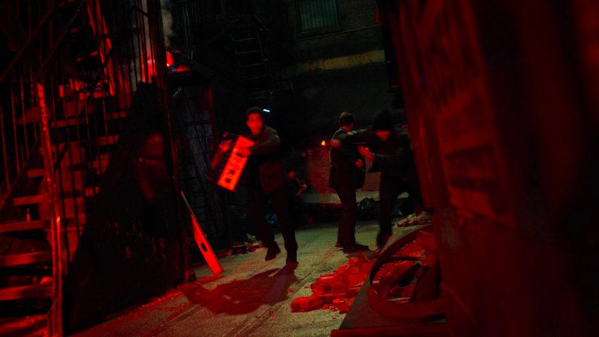 Youth running with a TV in an alley outside a pawn shop exit.