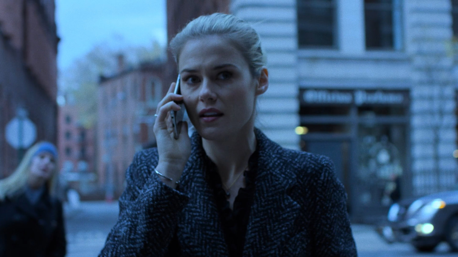 Trish on her cell phone walking across street.