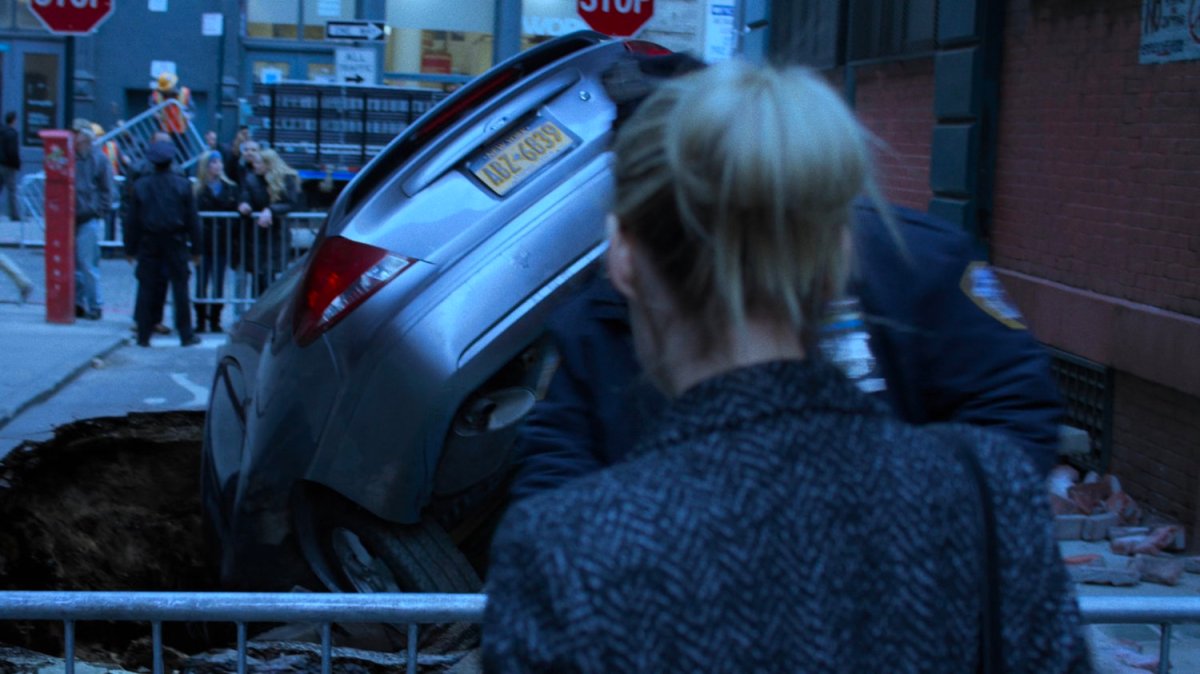 Trish sees a car swallowed up by the street.