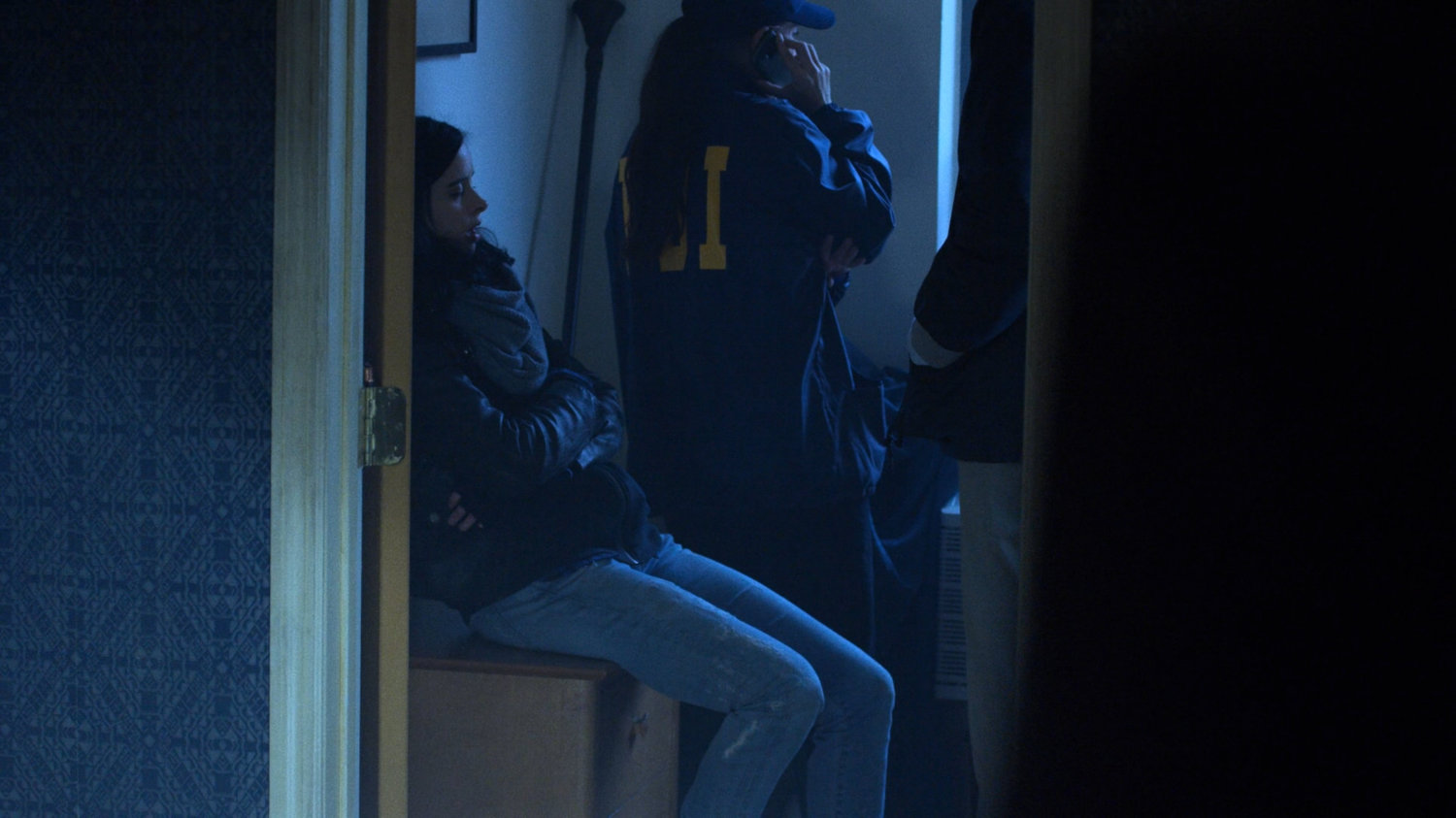 Jessica Jones and FBI agent in John Raymond's motel room.