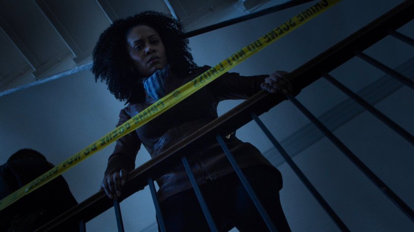 Misty looking over railing into stairway of John Raymond's motel building.