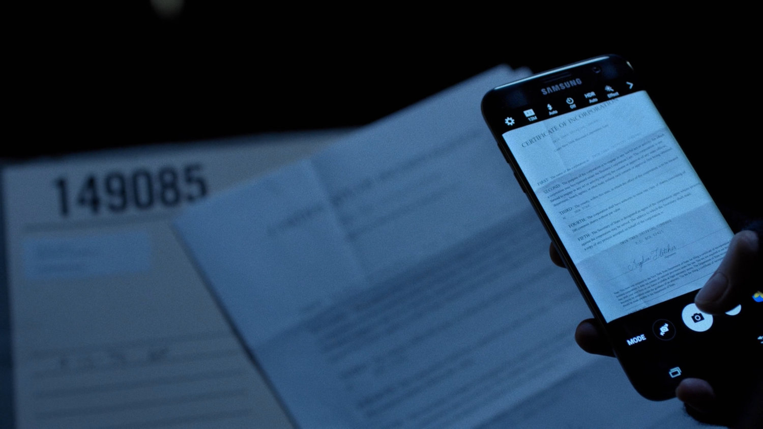 Close-up of cell phone taking picture of Transfer of Assets for the Twin Oaks Shipping Company in the New York Archives.