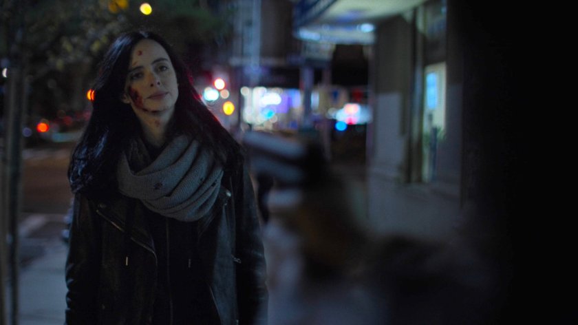 A bloody Jessica on the sidewalk outside her building.