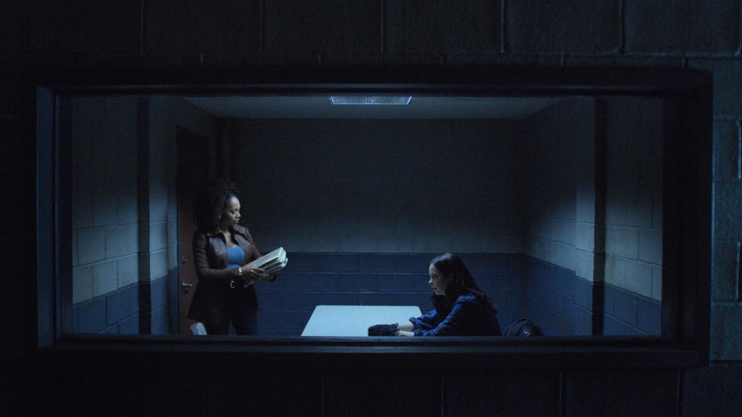 Misty and Jessica in a police interrogation room.