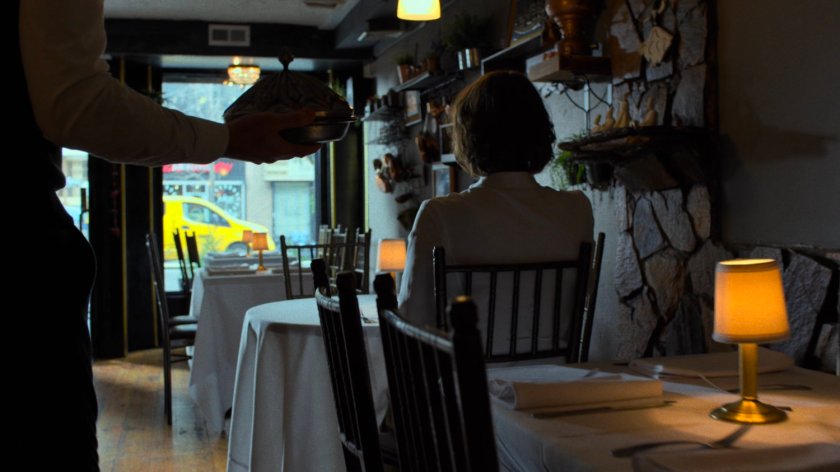 Server walking through empty Turkish restaurant towards Alexandra.