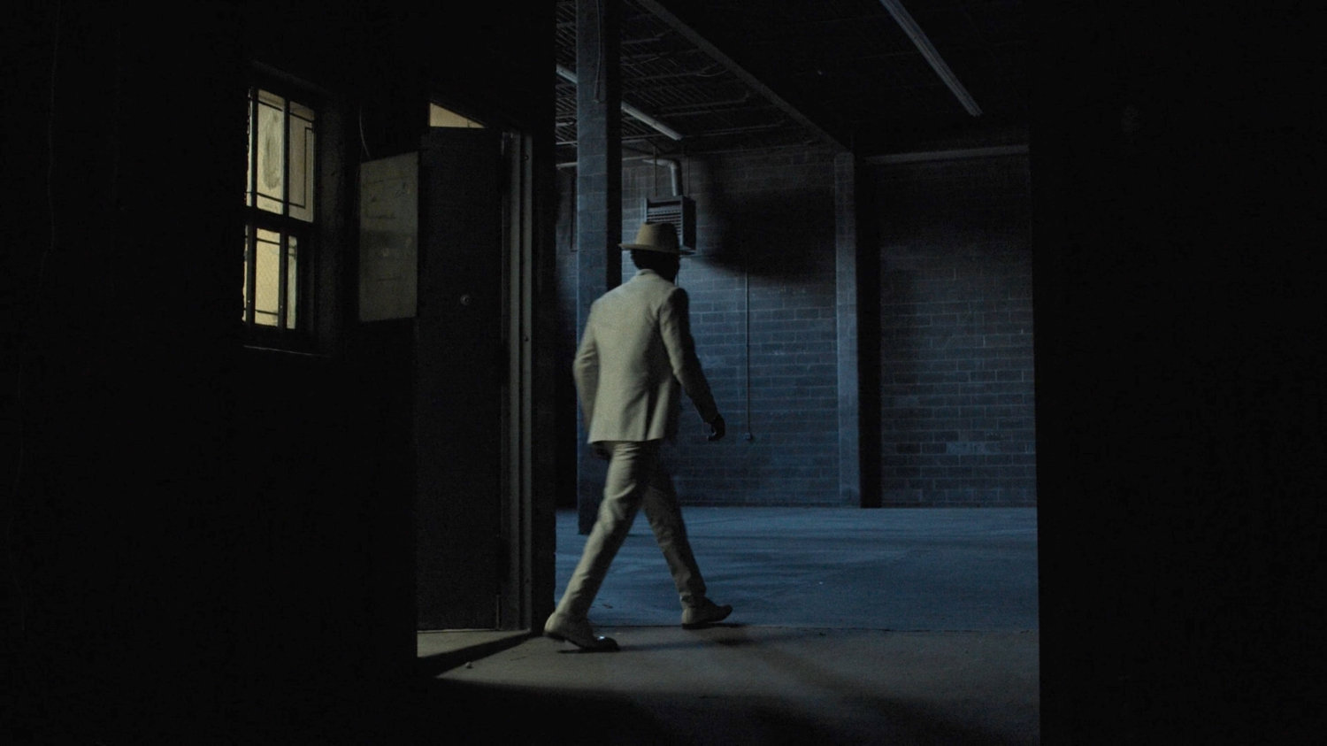 White Hat enters a dark warehouse.