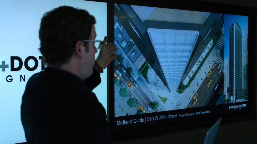 An architect at Duncan & Dotter Design shows Jessica some of their buildings.