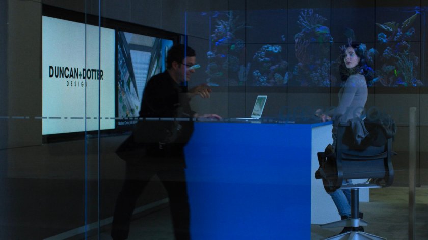 An architect at Duncan & Dotter Design shows Jessica some of their buildings.