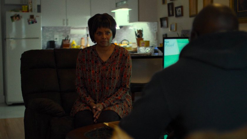 Luke sits with Dolores Miller in her apartment.