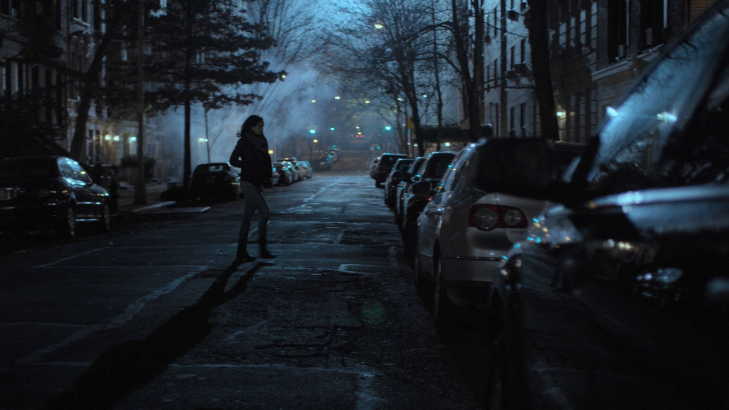 Jessica crosses the street outside the Raymond brownstone.