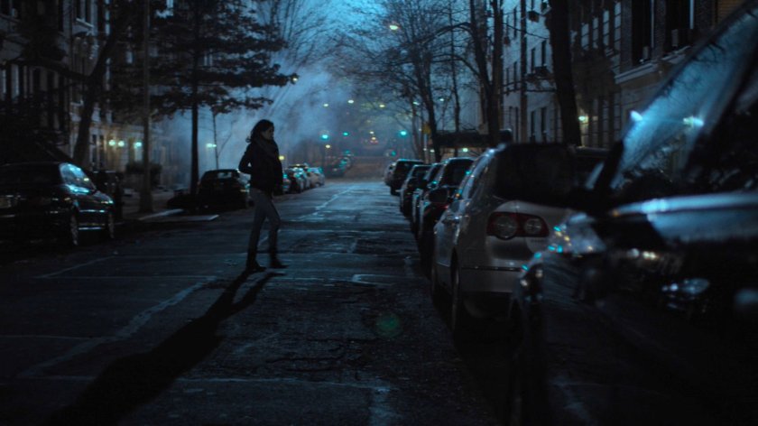 Jessica crosses the street outside the Raymond brownstone.