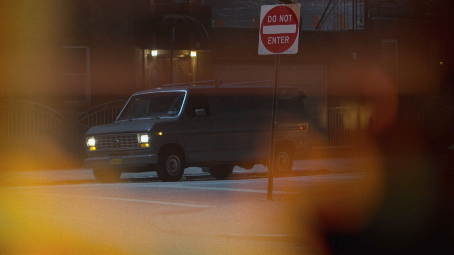 A van parked across the street from the Royal Dragon Chinese Restaurant as seen through mini blinds.