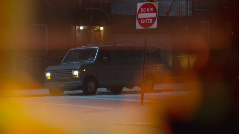 A van parked across the street from the Royal Dragon Chinese Restaurant as seen through mini blinds.