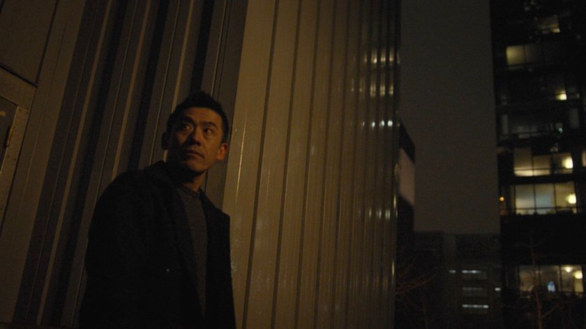 Murakmai walking down a small flight of stairs into an alley.