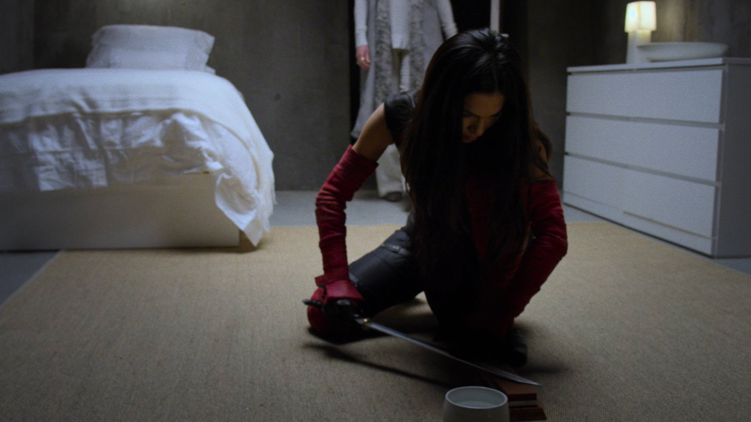 Elektra sharpening her sword in the Hand Compound.
